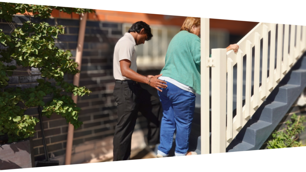 physiotherapist working with client on improving going up stairs at home