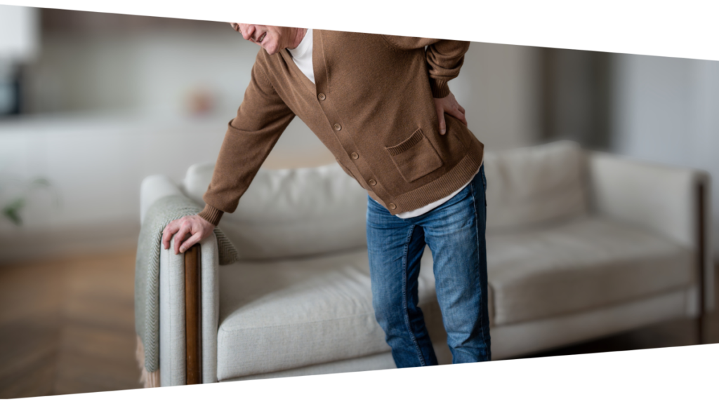 Person experiencing back pain in the living room at home