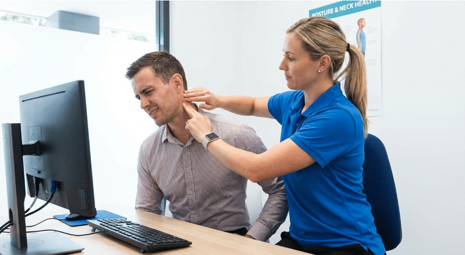 Physiotherapist assessing neck pain caused by desk posture